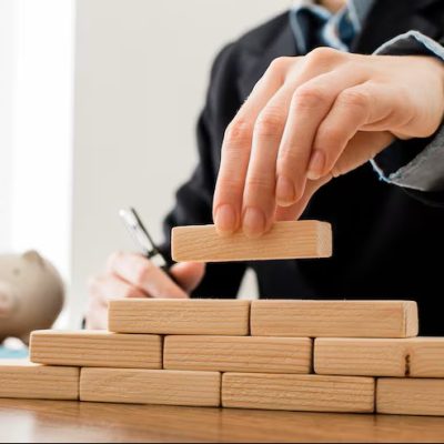 front-view-businessman-with-wooden-building-blocks_23-2148780640